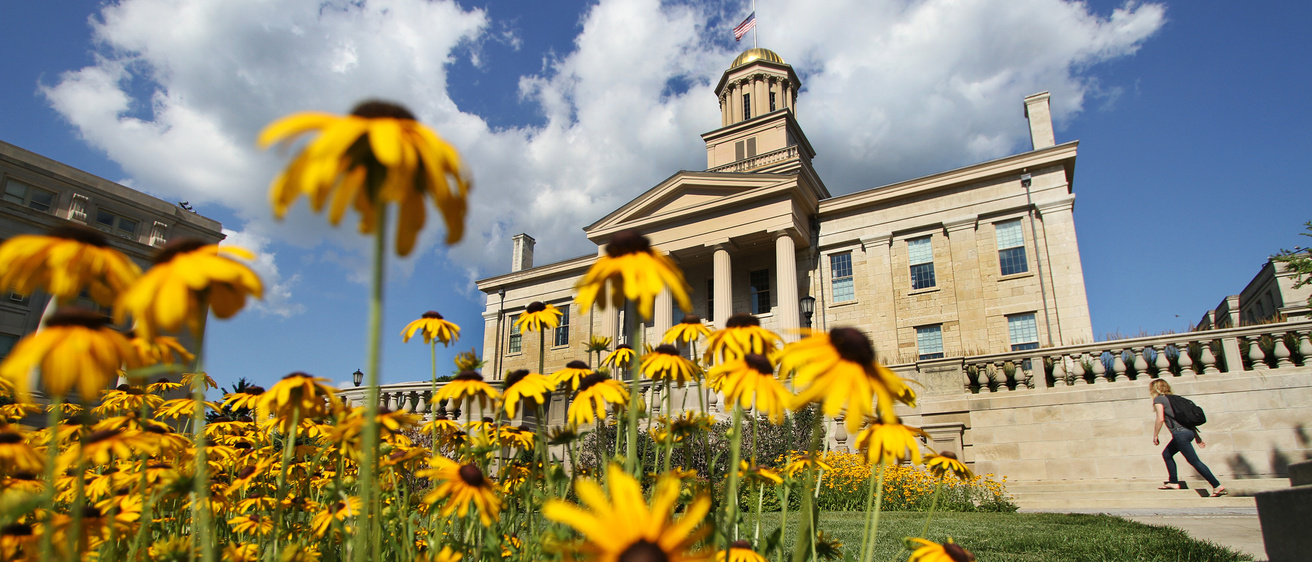 Colorful yellow flowers in front of the Old Capitol building on the campus of the University of Iowa.